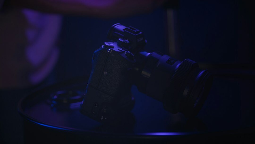 Close up of a professional broadcast camera on a TV set with a crew member adjusting it